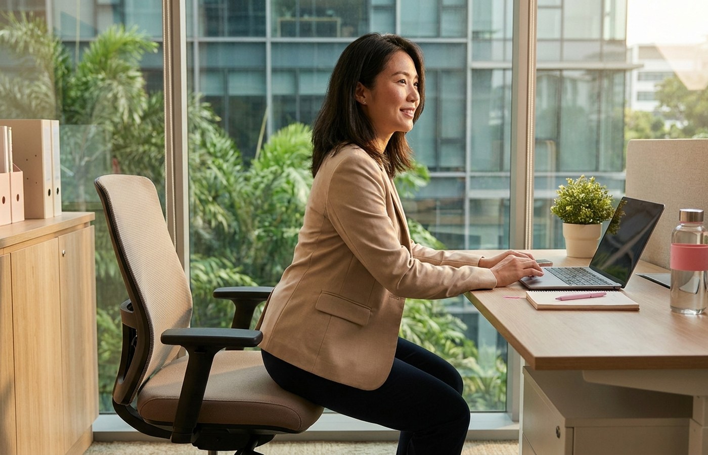 Office worker doing a controlled chair squat beside her desk
